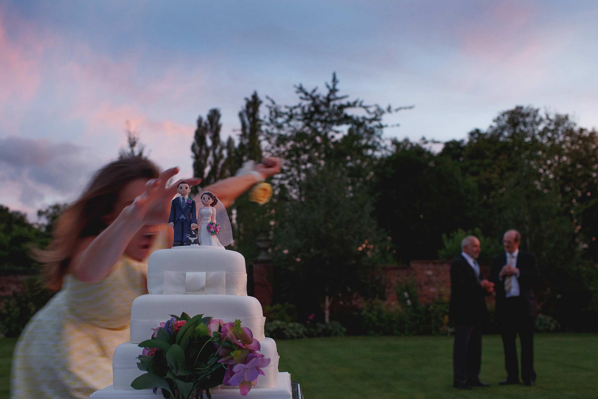 Award winning wedding photograph of someone almost knocking over a wedding cake at Colshaw Hall 