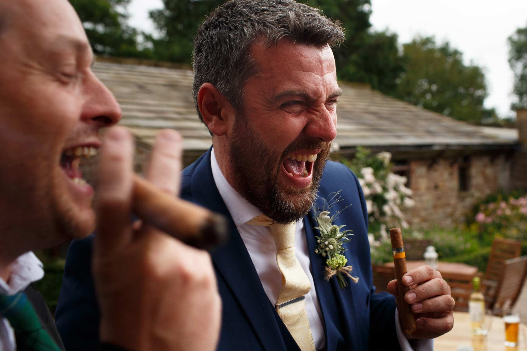 Groomsmen laughing smoking cigars at Browsholme Hall wedding