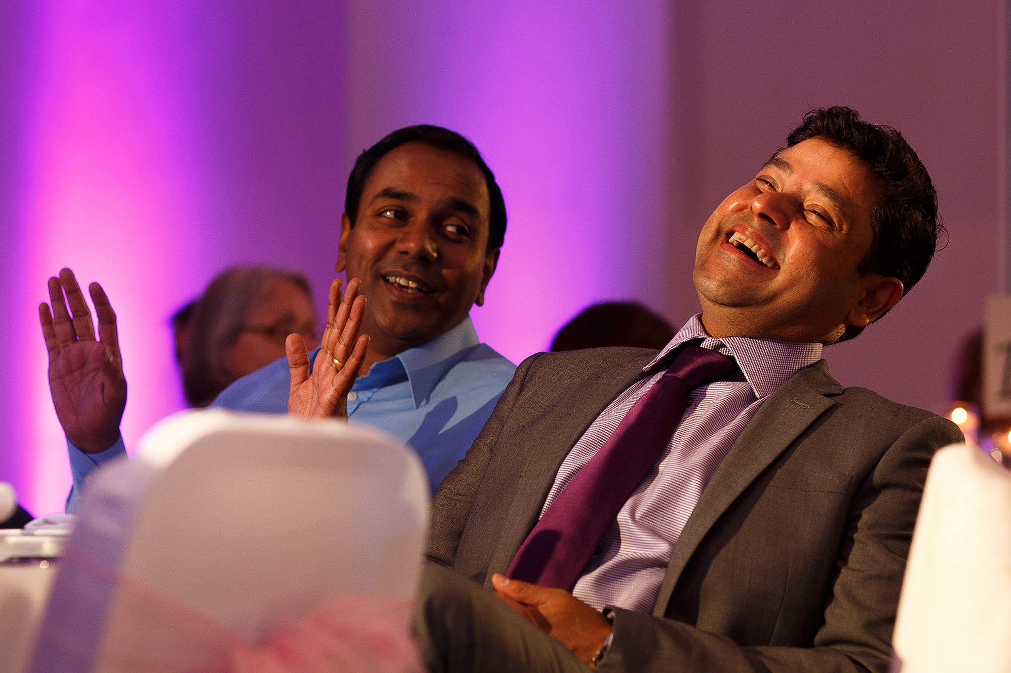 Guests laughing during speeches at Indian wedding reception