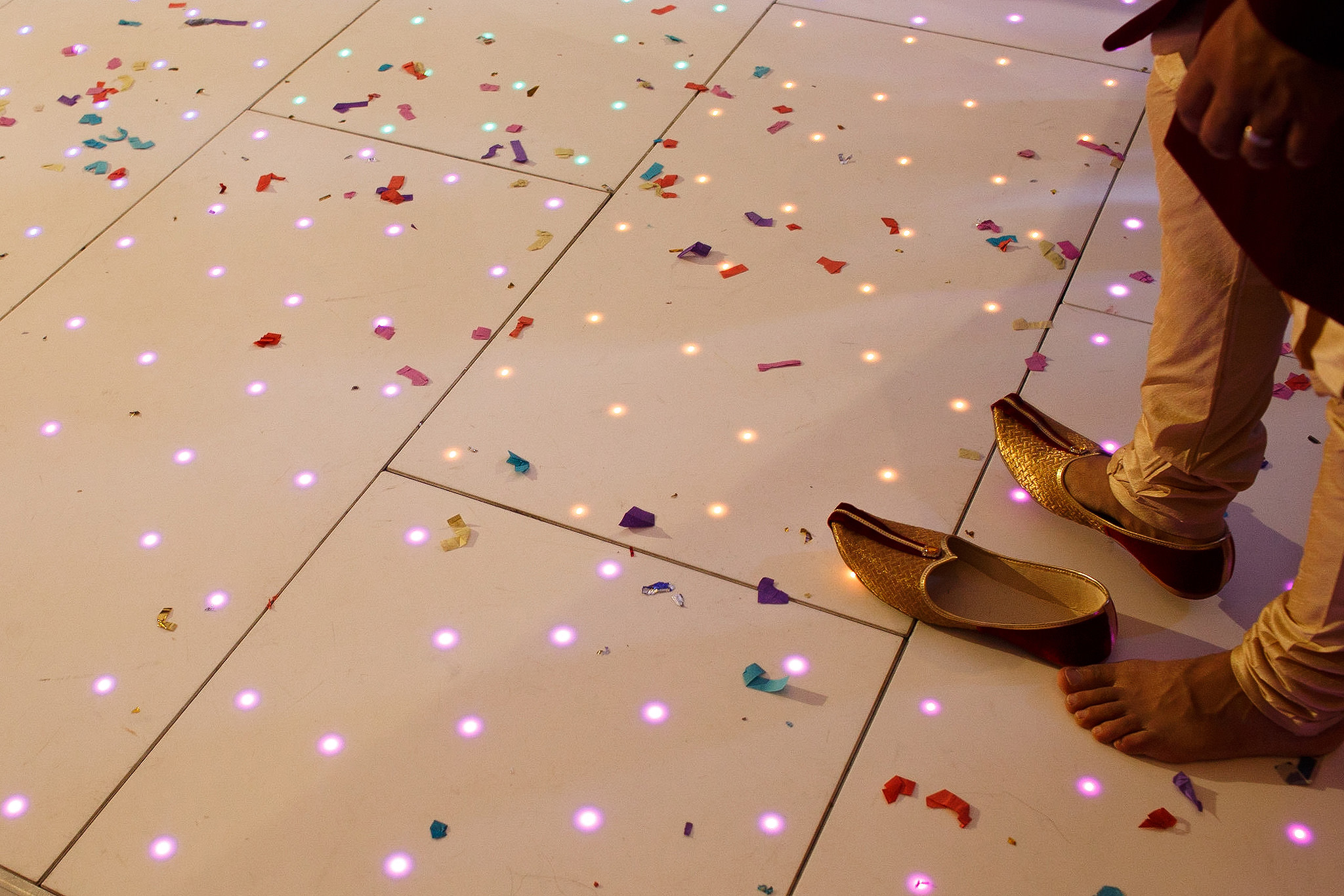Indian groom removed shoes on the dance floor at wedding reception