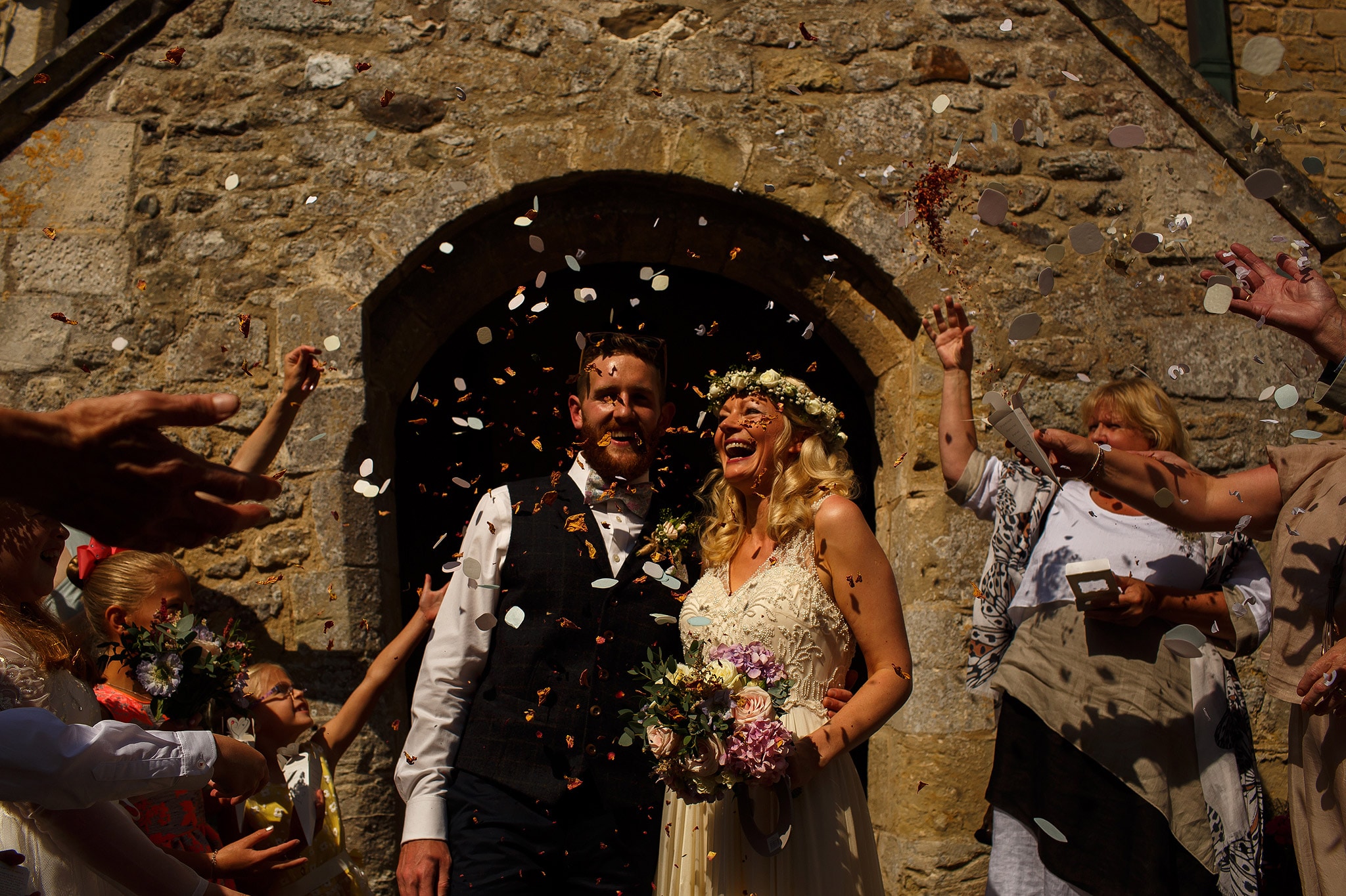 bride and groom laughing as confetti is thrown