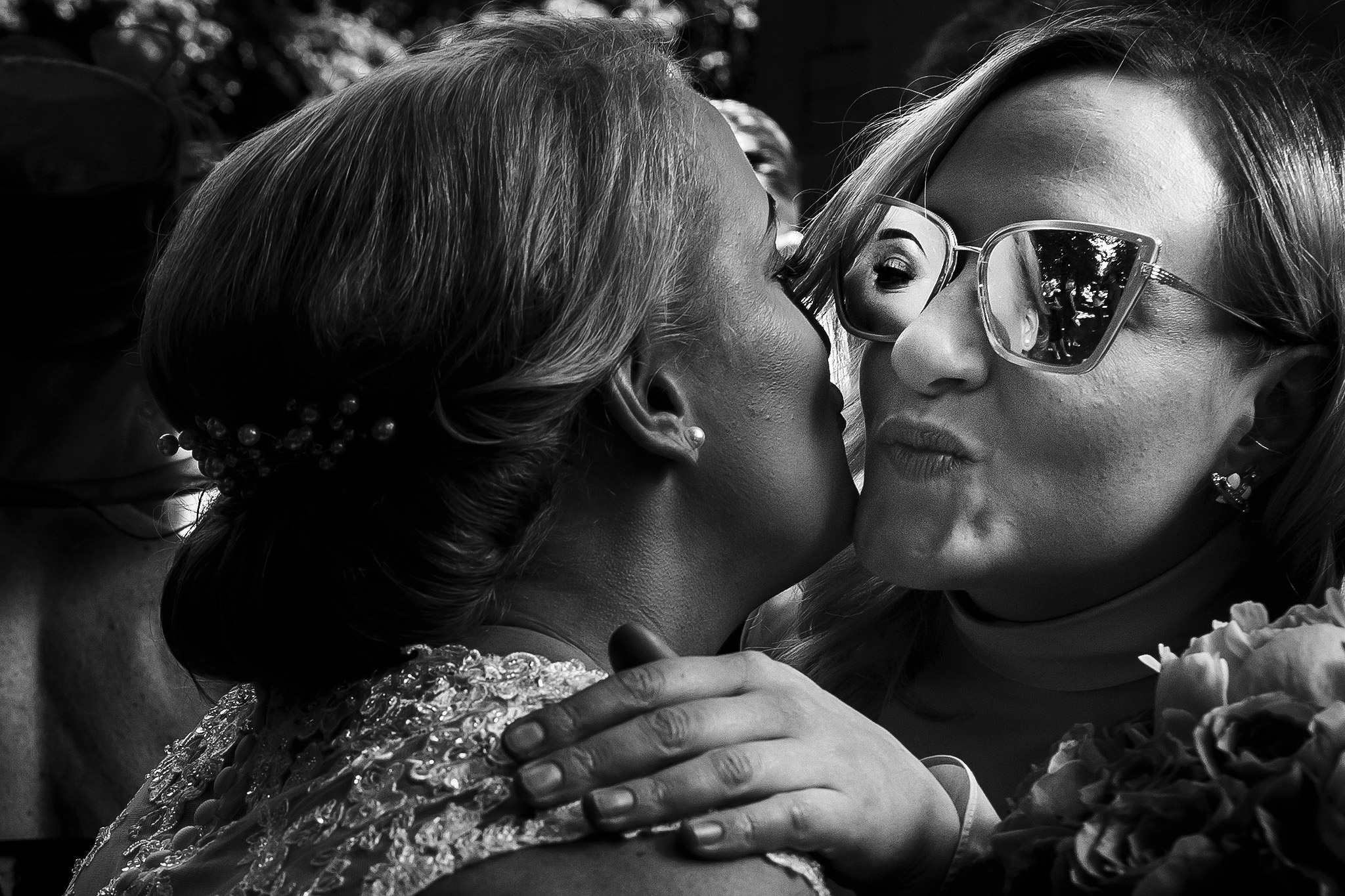 bride hugging guest with reaction in sunglasses