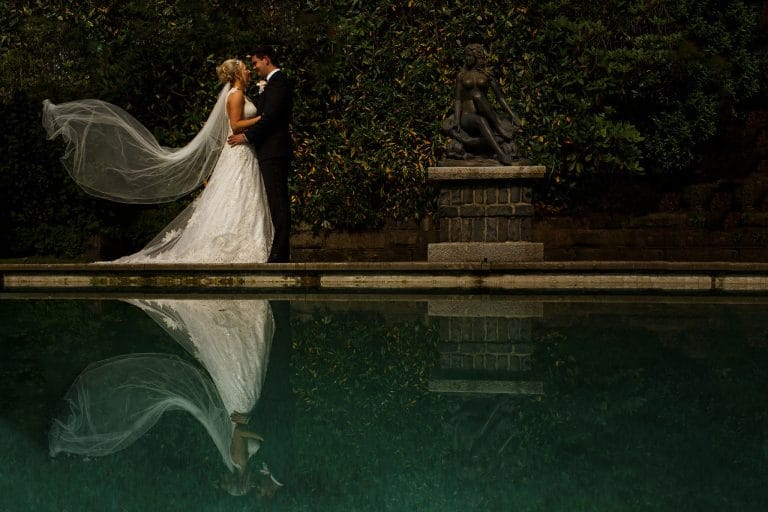 bride and groom across swimming pool with flowing veil at saddleworth hotel