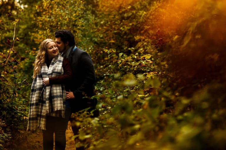 Autumn engagement shoot in the woods with golden leaves.