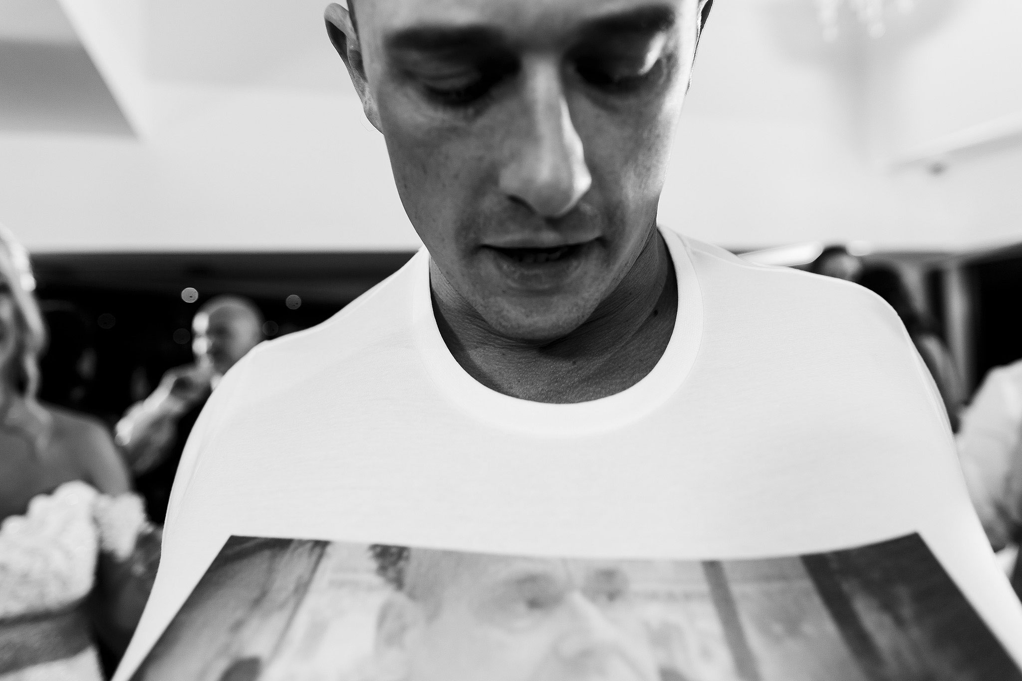 Black and white photograph of groom looking down at his t shirt