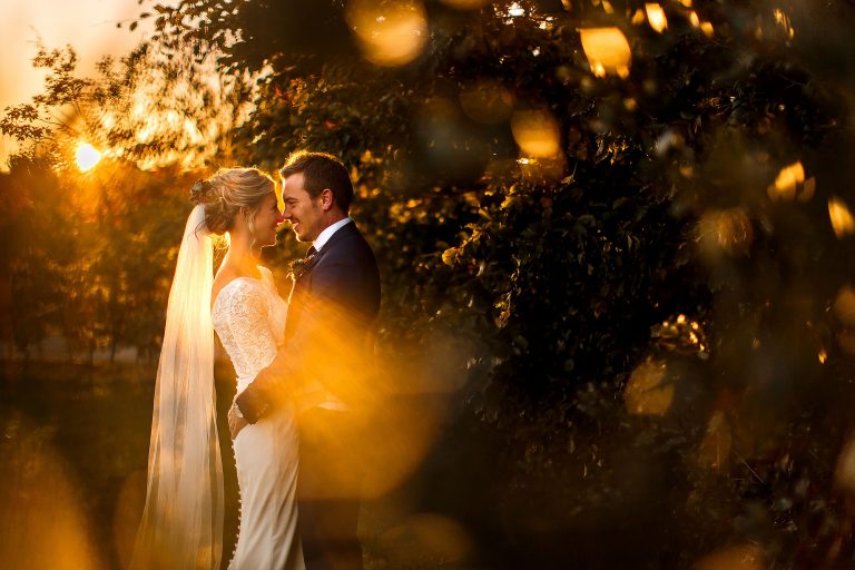 Bride and Groom in the gardens during golden hour sunset photoshoot with bokeh - The Out Barn at Clough Bottom Wedding Photography